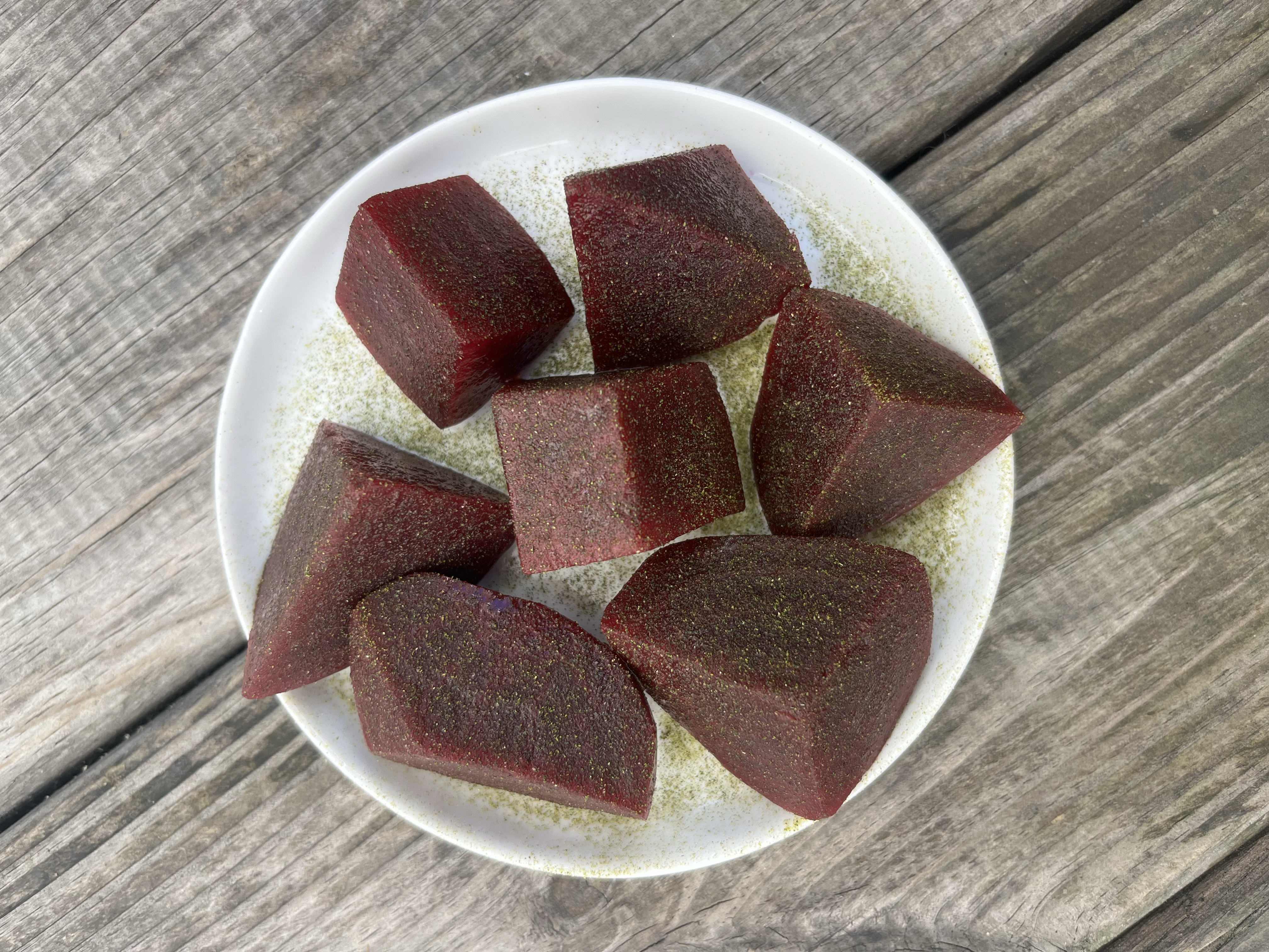 Colorful plate of fermented beets with summer squash and fig leaf salt, showcasing Cafe Lolo's creative use of seasonal Washington produce