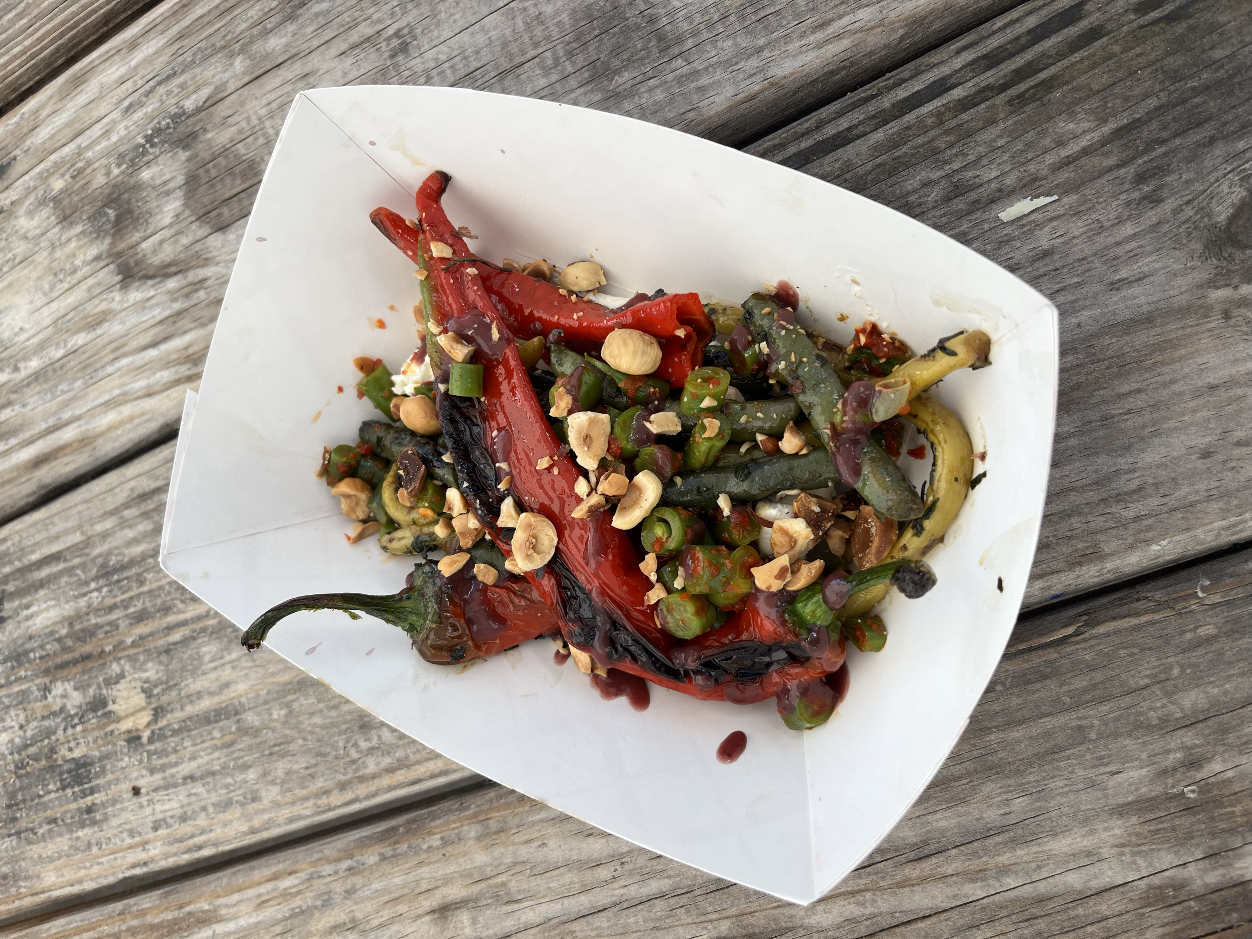 Artfully arranged pasta dish featuring Jimmy Nardello peppers, spicy pole beans, house-made ricotta, grape molasses and hazelnuts on rustic ceramic plate