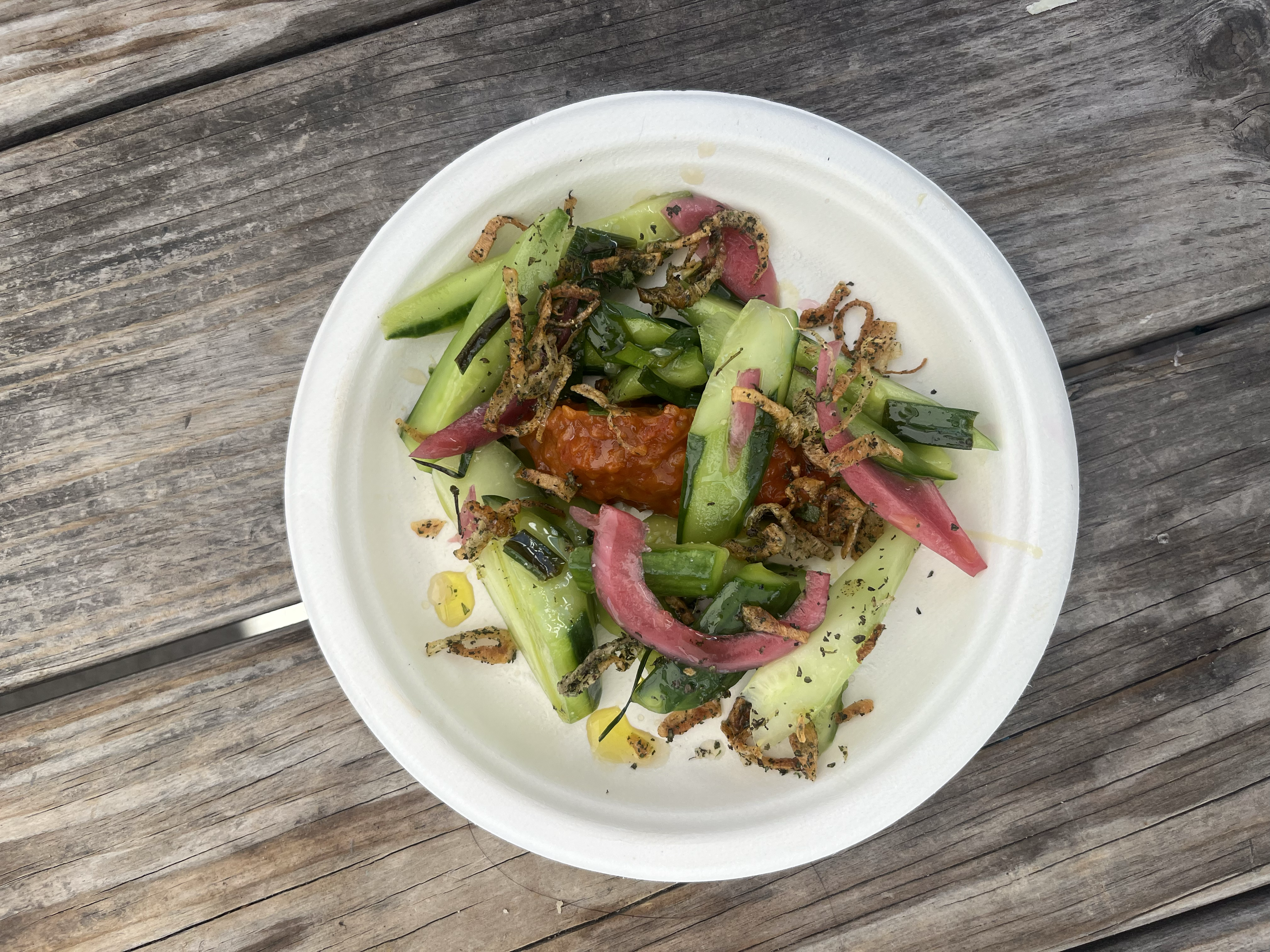Fresh cucumber salad with shiro plum vinegar, house-made tomato jam, crispy fried shallots and dried mint, presented in elegant white bowl